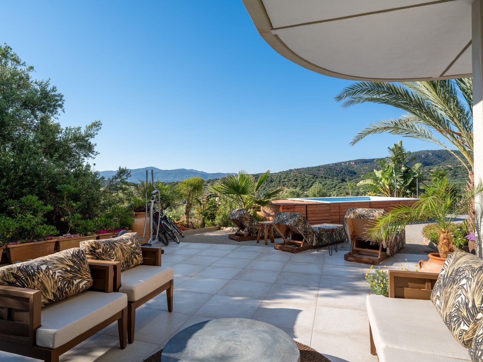 Lounge seating on the stone terrace beside the pool