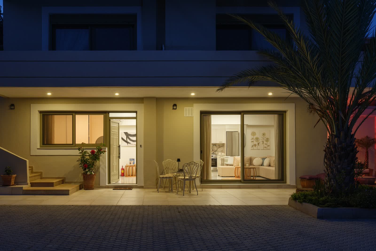 The house at dusk, every window glowing warm