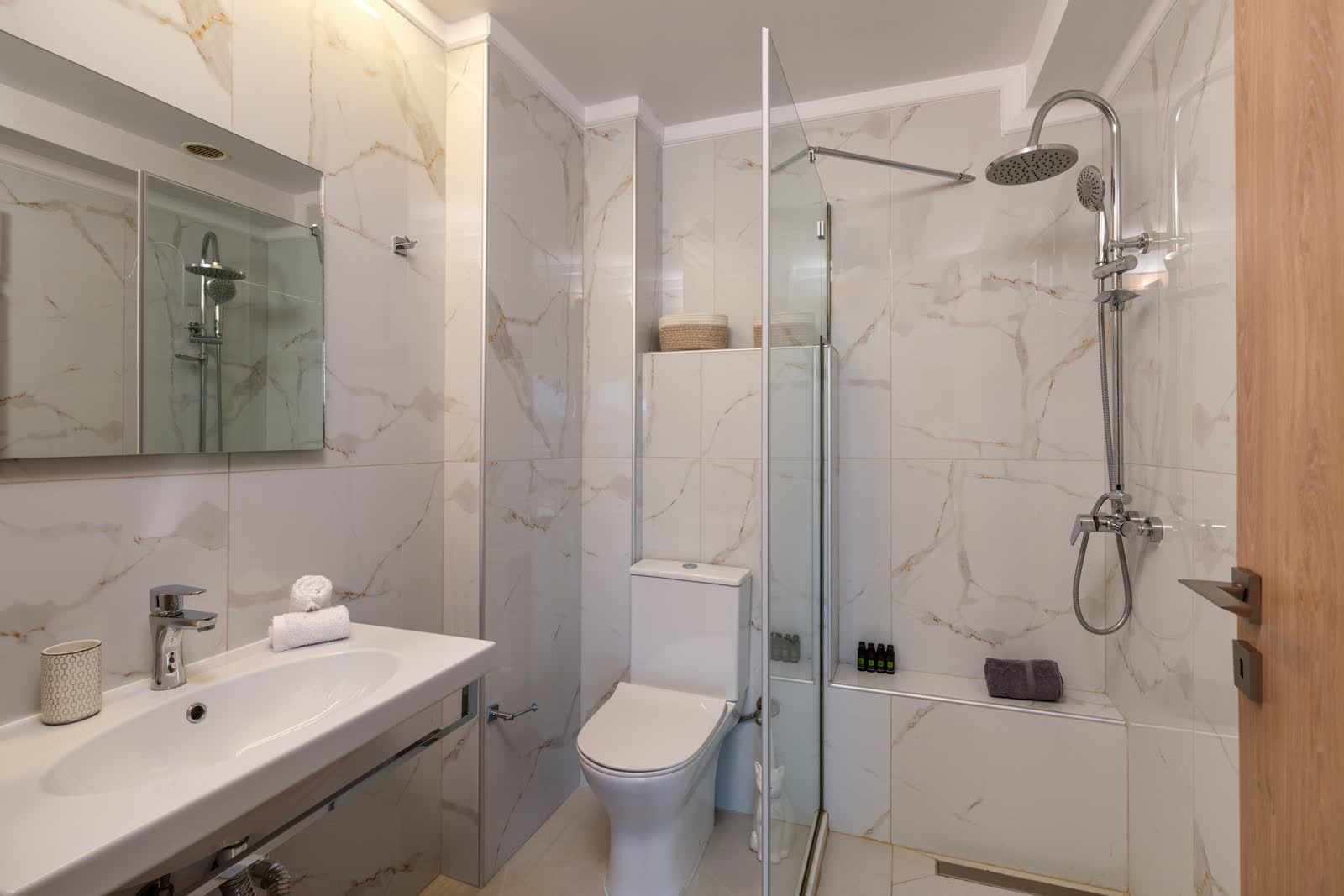 The marble bathroom — walk-in rain shower, basin and mirror