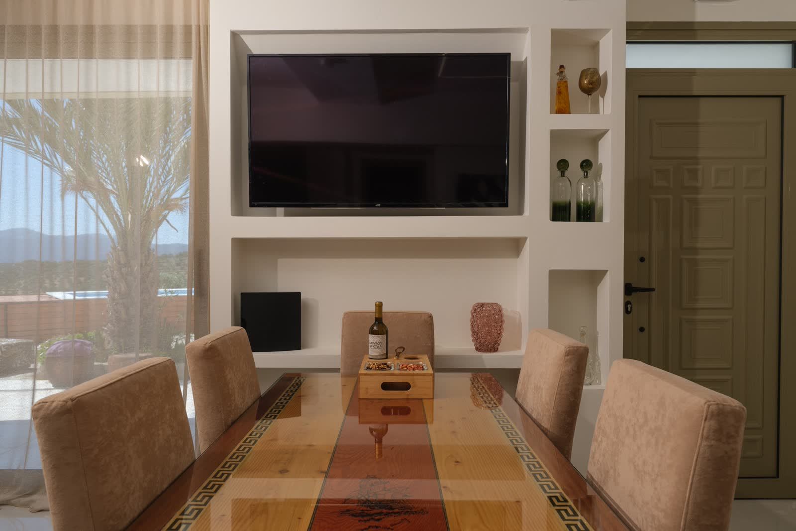 The dining table under the TV, the terrace just outside