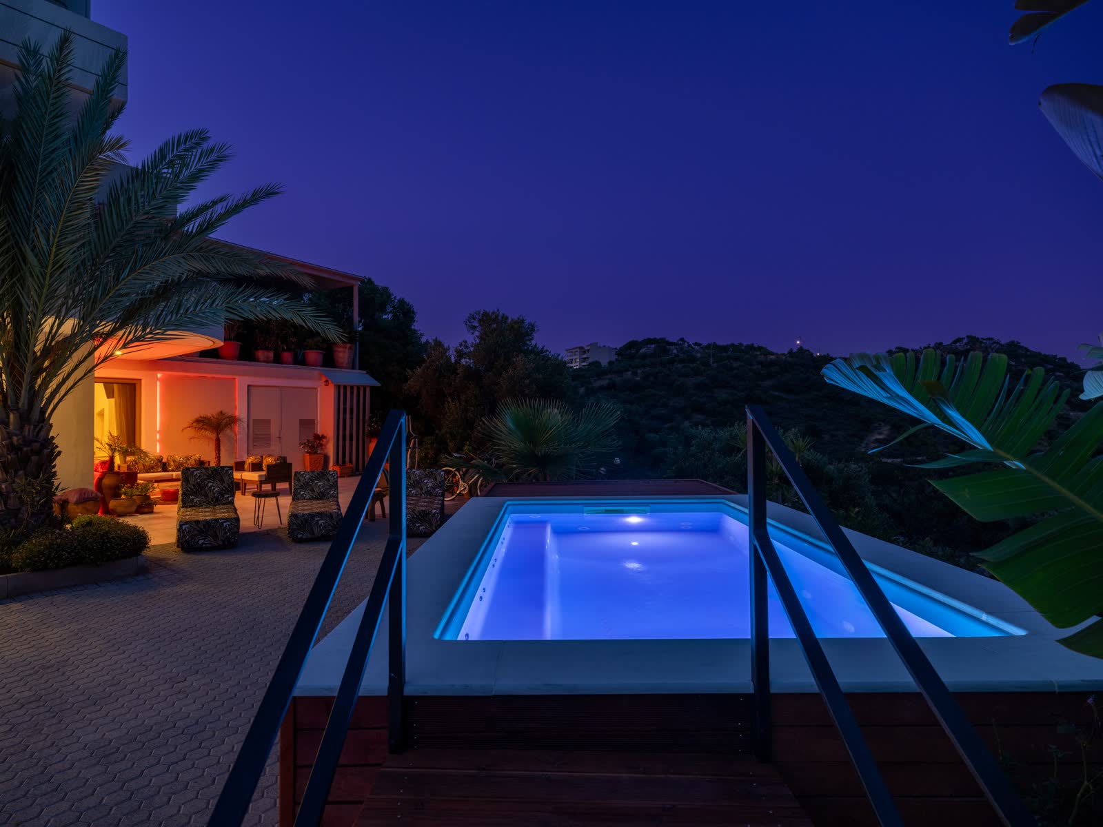 The pool lit blue at dusk